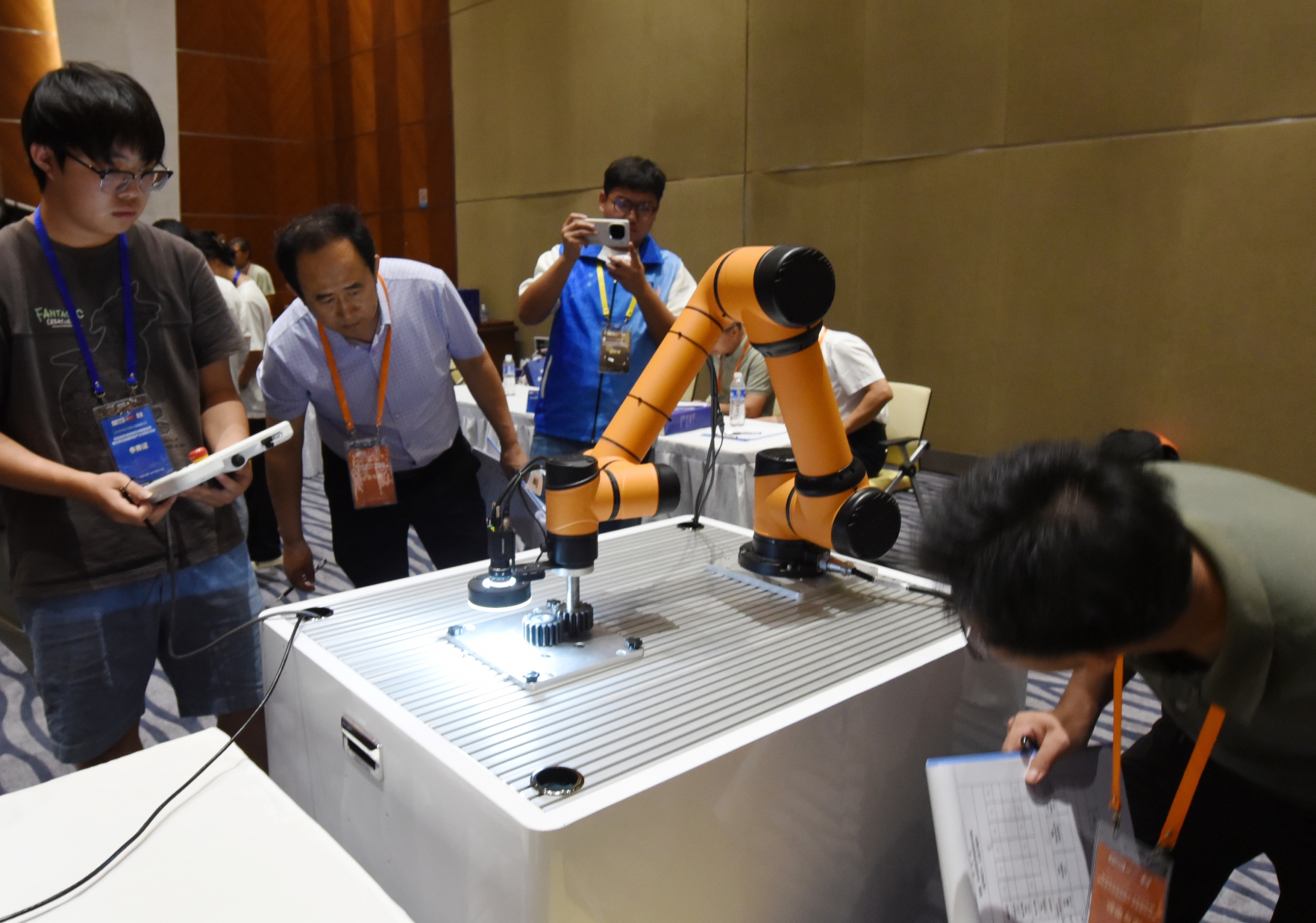 2025年中國(guó)大學(xué)生機(jī)械工程創(chuàng)新創(chuàng)意大賽智能精密裝配賽京津冀魯聯(lián)賽現(xiàn)場(chǎng)，評(píng)委對(duì)參賽選手進(jìn)行實(shí)操調(diào)試評(píng)比。